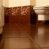 Hnedá podlaha v kúpeľni s toaletou a vaňou