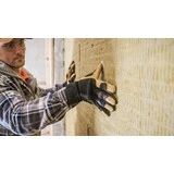 Renovácia zateplenie domu muž v šiltovke s rukavicami, ktorý zatepluje