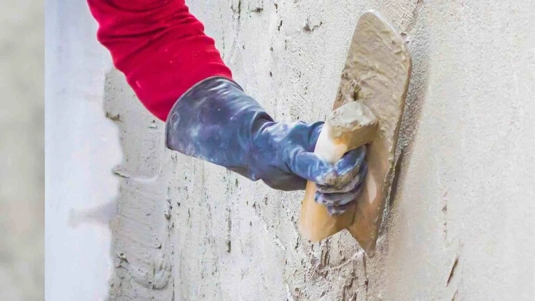 Aplikácia jadrovej omietky Aplikácia jadrovej omietky na múr hladidlom